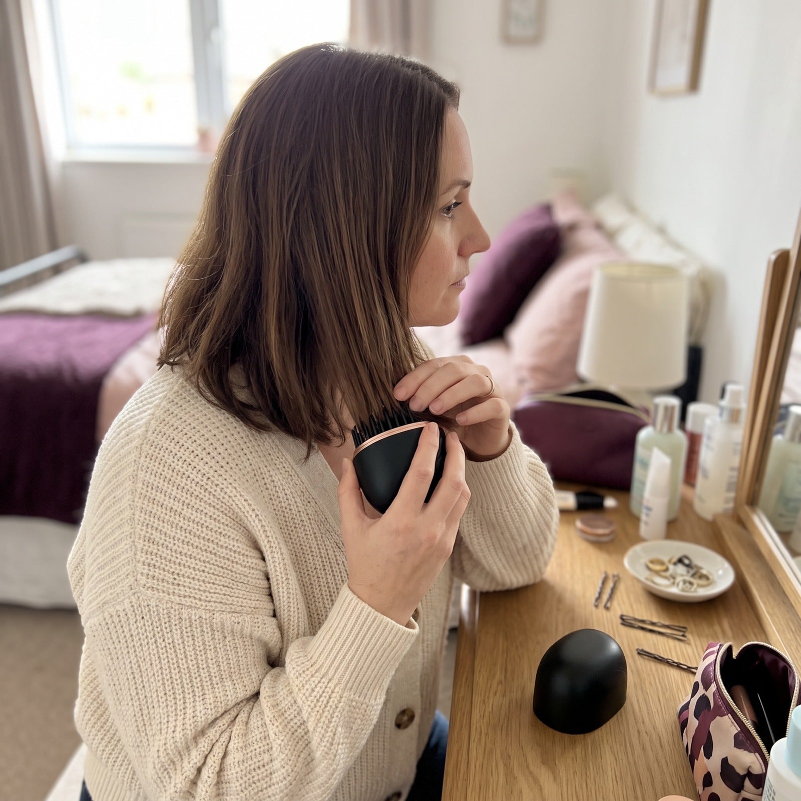 Black brush smoothing dry ends at a dresser